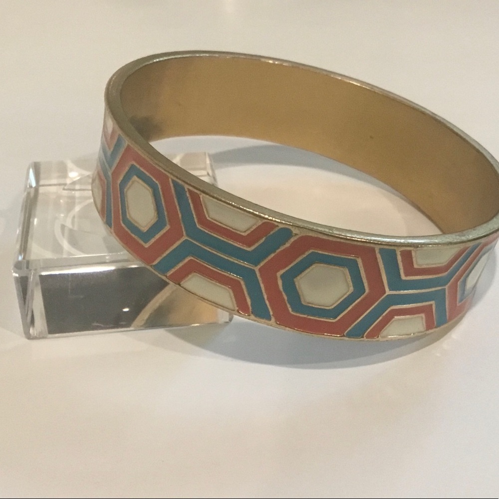 Solid bracelet with abstract design in retro colors. Gold-tone base.